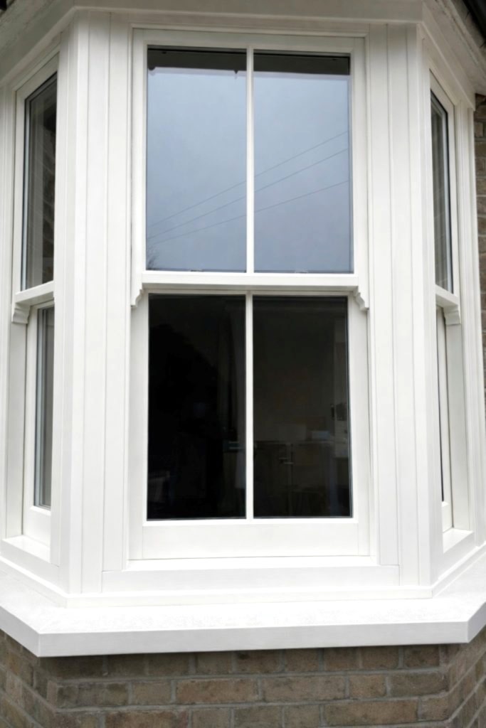 A beautiful Bygone Harmony sash window installation in Enfield, including a bay window and traditional timber-style features.